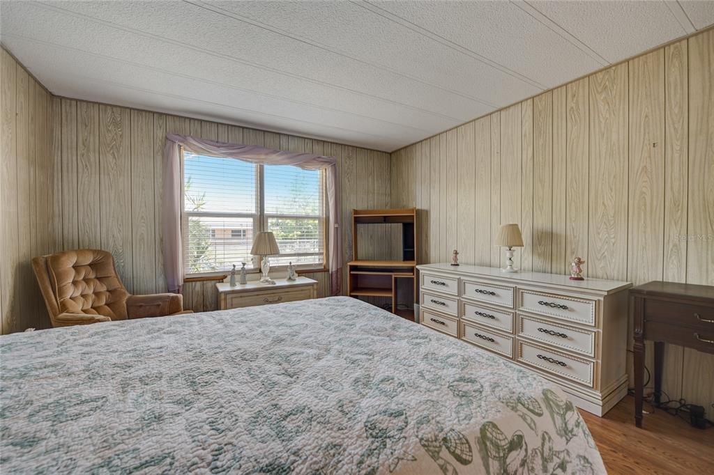 5619 Bayshore Road, Unit 312 Palmetto, FL 34221 - Photo 28 of 40 a large bedroom with a bed and a flat tv screen tv on dresser