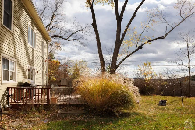 a view of a patio with table and chairs and potted plants with wooden floor and fence