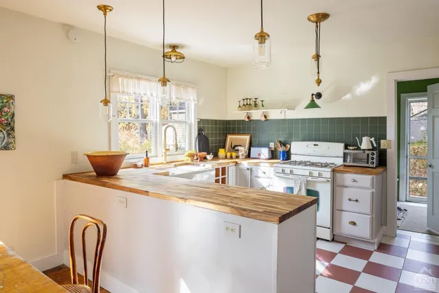 a kitchen with stainless steel appliances kitchen island granite countertop a sink a stove and a wooden floors