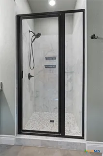 a bathroom with a glass shower door