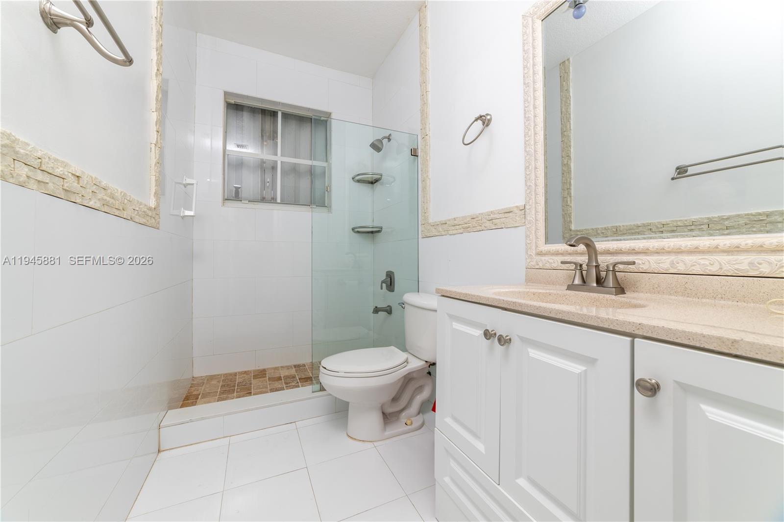 11504 Southwest 152nd Court Miami, FL 33196 - Photo 15 of 17 a bathroom with a granite countertop sink a toilet and a mirror