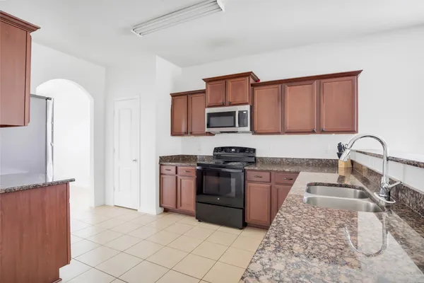 a kitchen with granite countertop a stove and a sink