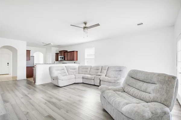 a living room with furniture white walls and wooden floor
