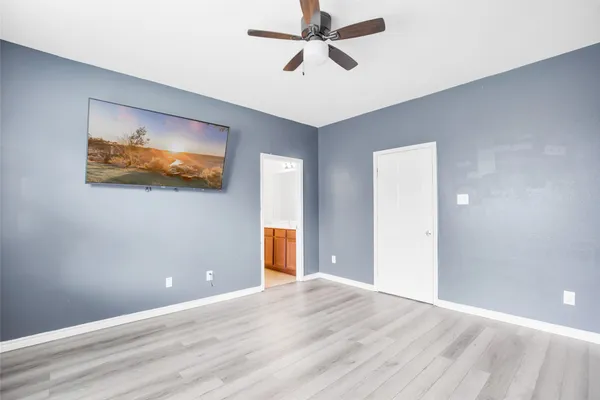 a view of a room with wooden floor and ceiling fan
