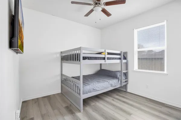 a bedroom with a bed and a chandelier fan