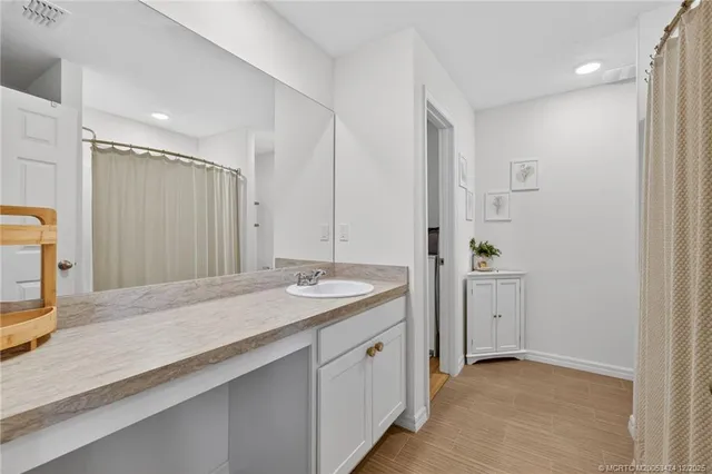 a spacious bathroom with a granite countertop sink and a mirror