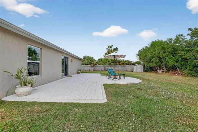 a view of a house with backyard and sitting area