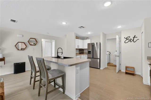 a kitchen with stainless steel appliances a table and chairs in it