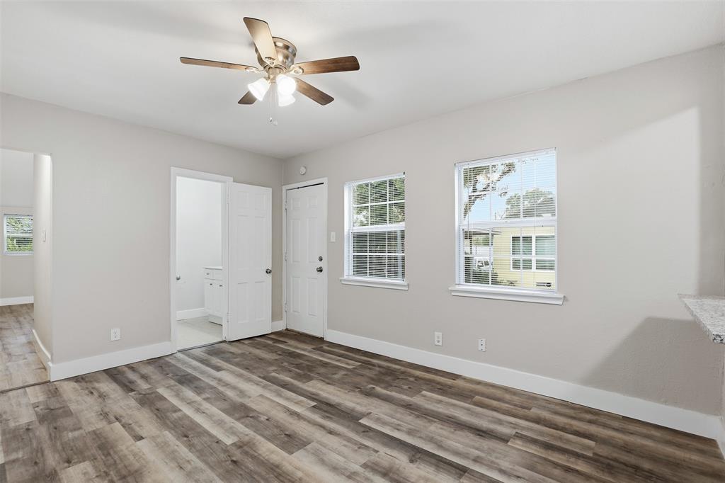 227 South Hampton Road Dallas, TX 75208 - Photo 20 of 32 Unfurnished bedroom with multiple windows, wood finished floors, and a ceiling fan