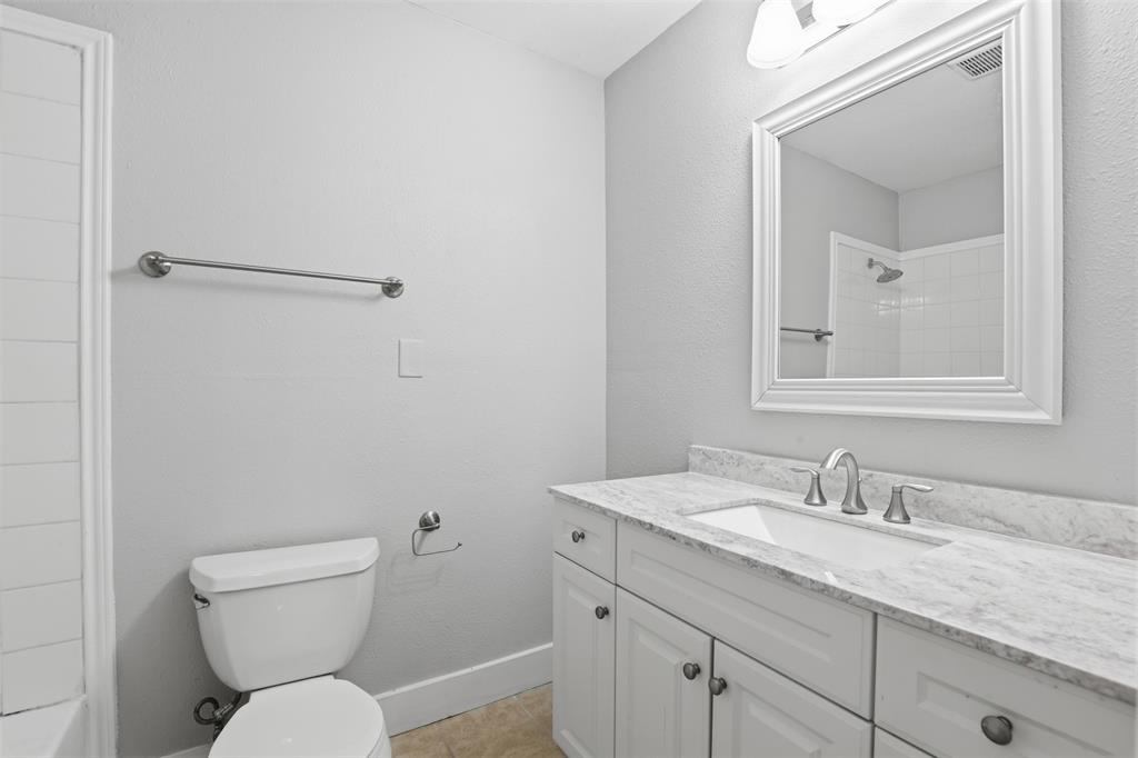 227 South Hampton Road Dallas, TX 75208 - Photo 28 of 32 Bathroom featuring vanity, light tile patterned floors, tub / shower combination, and a textured wall