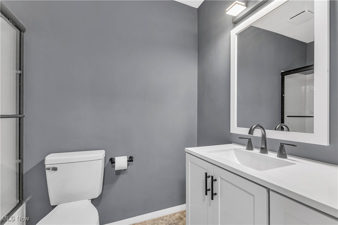 6640 Pearl Road, Unit 104 Cleveland, OH 44130 - Photo 19 of 31 Bathroom with toilet, vanity, an enclosed shower, and baseboards