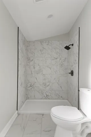 a white toilet sitting next to a bath tub and shower