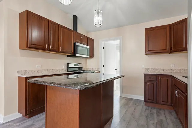 a kitchen with stainless steel appliances granite countertop a sink stove and microwave