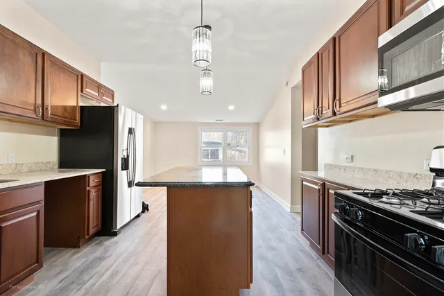 a kitchen with stainless steel appliances granite countertop a stove and a refrigerator