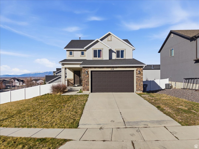 1218 Moonlight Drive Elk Ridge, UT 84651 - Photo 2 of 44 Traditional-style home featuring a porch, concrete driveway, an attached garage, and stone siding