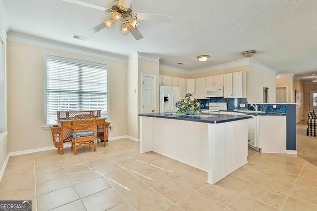 a kitchen with cabinets and chairs