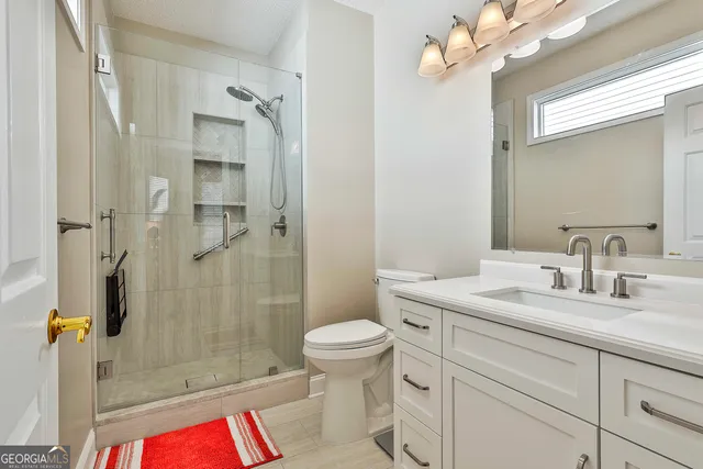 a bathroom with a sink a toilet and shower