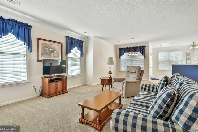a living room with furniture a flat screen tv and kitchen area