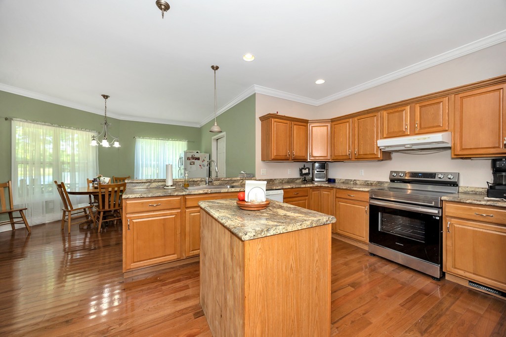 84 Scott Orchard Road Taft, TN 38488 - Photo 10 of 23 a kitchen with stainless steel appliances granite countertop a stove top oven a sink dishwasher a dining table and chairs with wooden floor