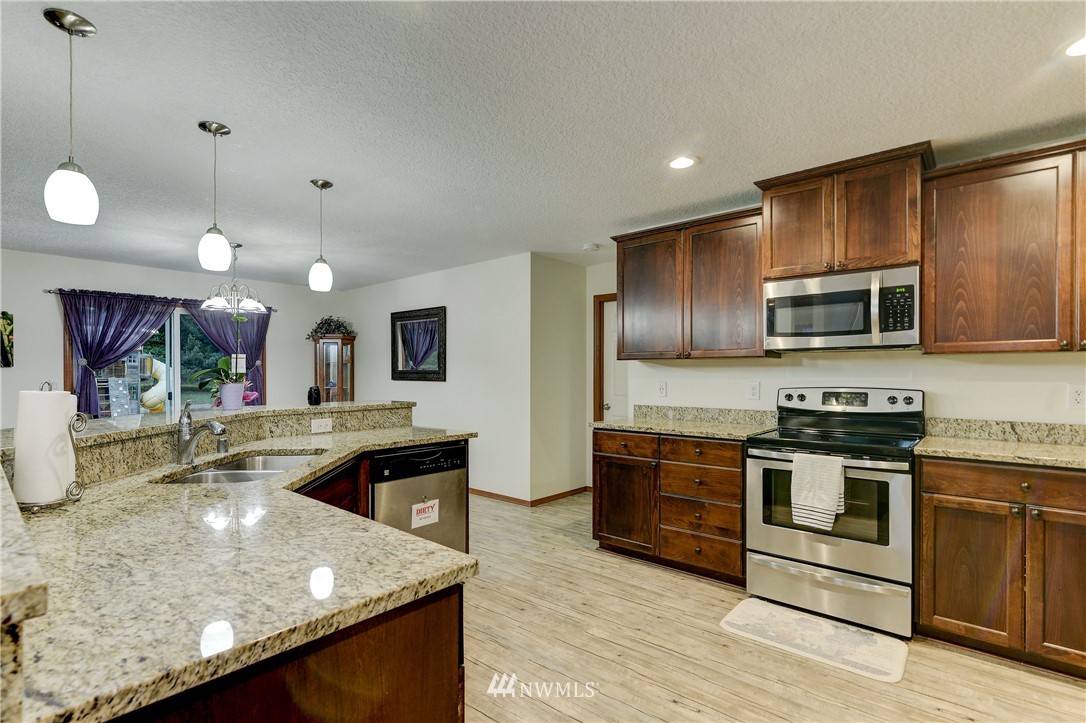19520 Grand Mound Way Southwest Rochester, WA 98579 - Photo 12 of 34 a kitchen with stainless steel appliances granite countertop a stove a sink and a microwave