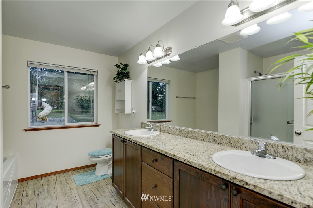 19520 Grand Mound Way Southwest Rochester, WA 98579 - Photo 16 of 34 a bathroom with a granite countertop sink a large mirror and a window