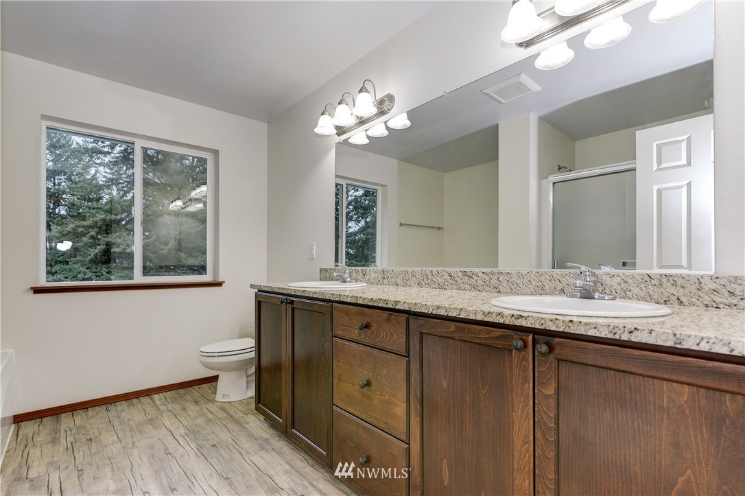 19520 Grand Mound Way Southwest Rochester, WA 98579 - Photo 20 of 34 a bathroom with a granite countertop toilet a sink and a large mirror