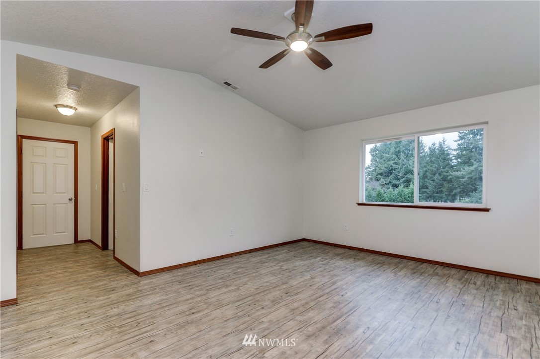 19520 Grand Mound Way Southwest Rochester, WA 98579 - Photo 23 of 34 an empty room with wooden floor fan and windows