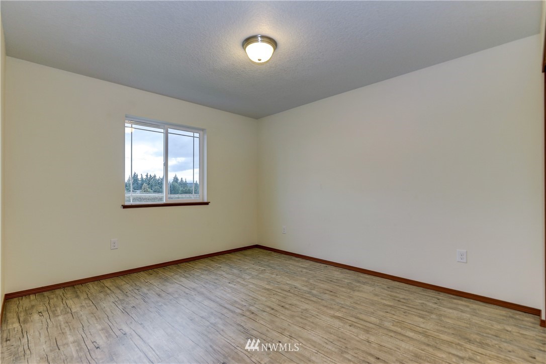 19520 Grand Mound Way Southwest Rochester, WA 98579 - Photo 27 of 34 an empty room with wooden floor and windows