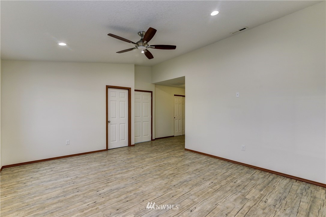 19520 Grand Mound Way Southwest Rochester, WA 98579 - Photo 29 of 34 an empty room with a ceiling fan and wooden floor
