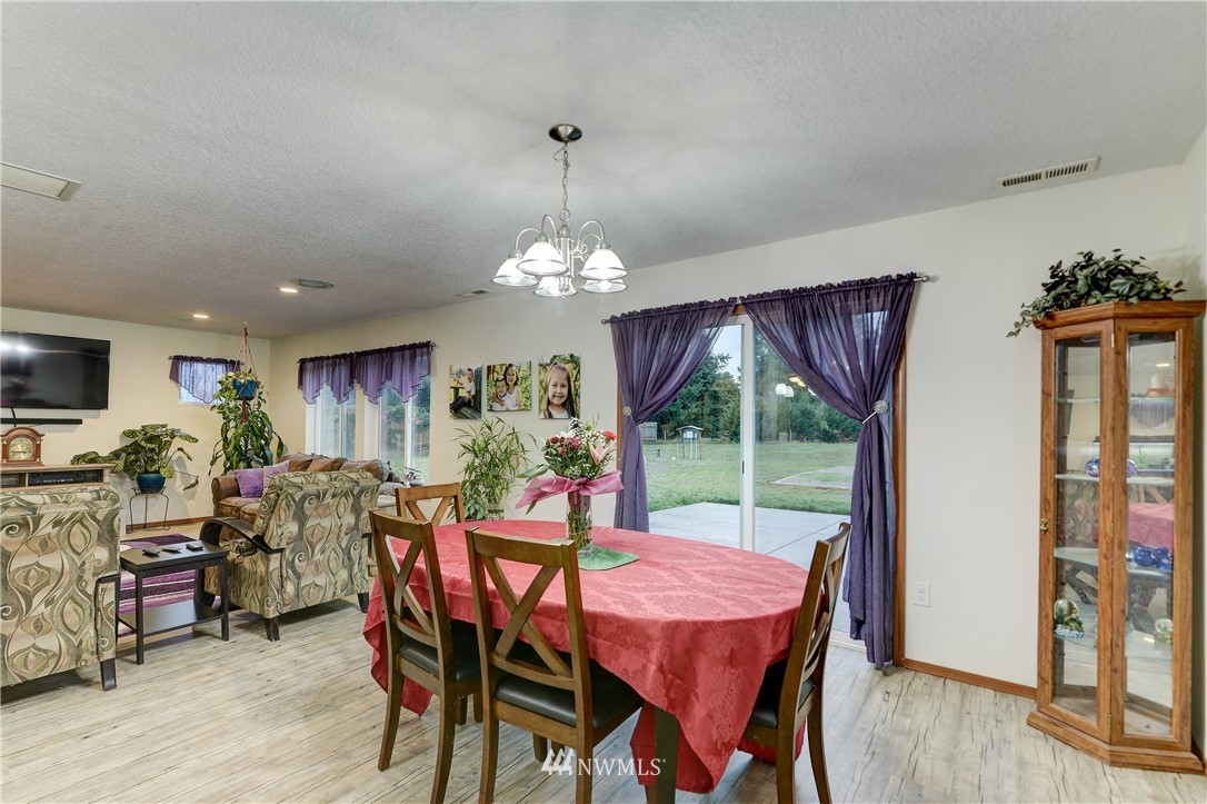 19520 Grand Mound Way Southwest Rochester, WA 98579 - Photo 8 of 34 a dining room with furniture a chandelier and wooden floor