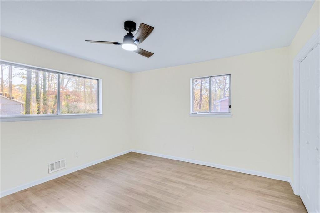 6695 Cedar Hurst Trail Atlanta, GA 30349 - Photo 12 of 24 a view of an empty room with a window and a ceiling fan