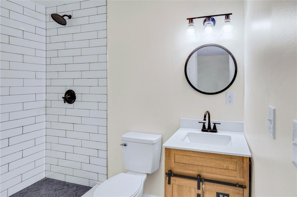 6695 Cedar Hurst Trail Atlanta, GA 30349 - Photo 15 of 24 a bathroom with a sink a toilet and a mirror