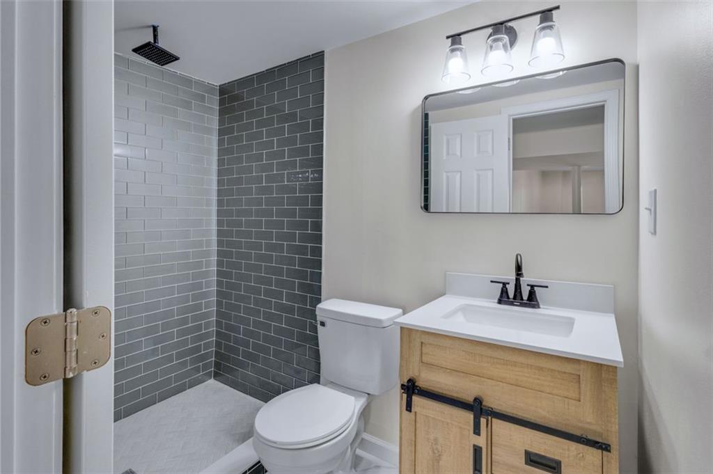 6695 Cedar Hurst Trail Atlanta, GA 30349 - Photo 20 of 24 a bathroom with a sink a toilet and mirror