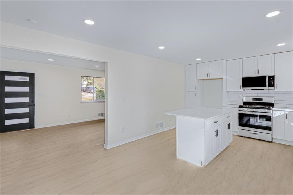 6695 Cedar Hurst Trail Atlanta, GA 30349 - Photo 5 of 24 a kitchen with granite countertop a stove and a sink