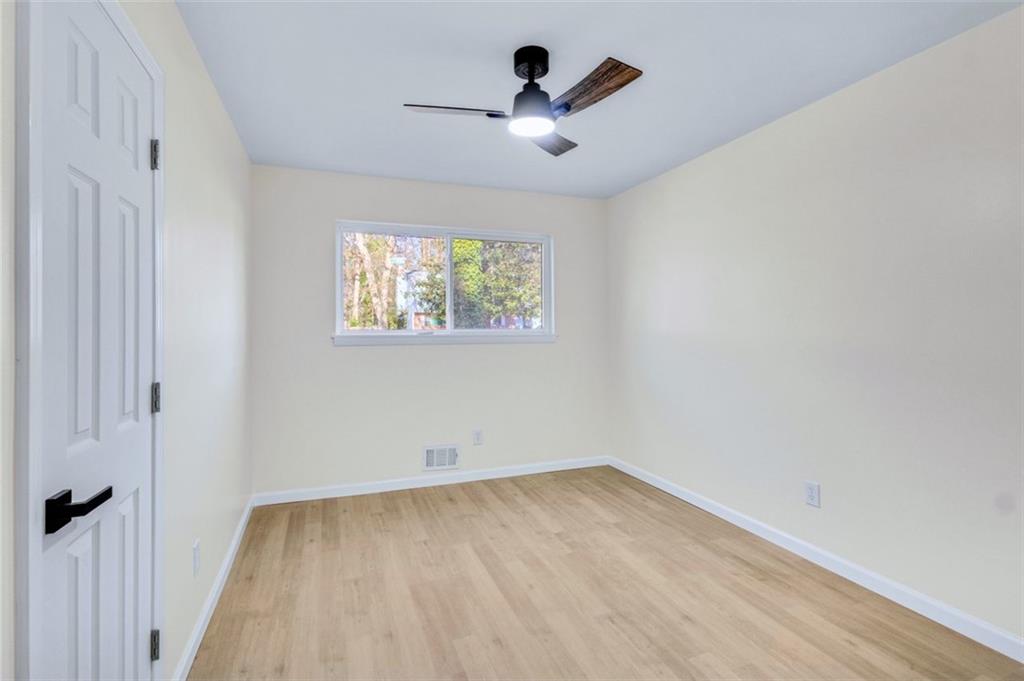 6695 Cedar Hurst Trail Atlanta, GA 30349 - Photo 8 of 24 wooden floor in an empty room with a window