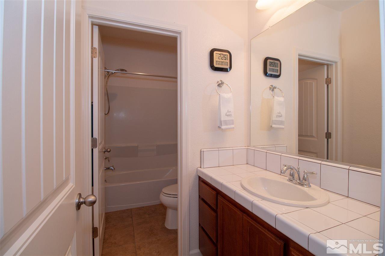 1945 Hope Valley Drive Reno, NV 89521 - Photo 14 of 22 a bathroom with a granite countertop sink toilet and shower
