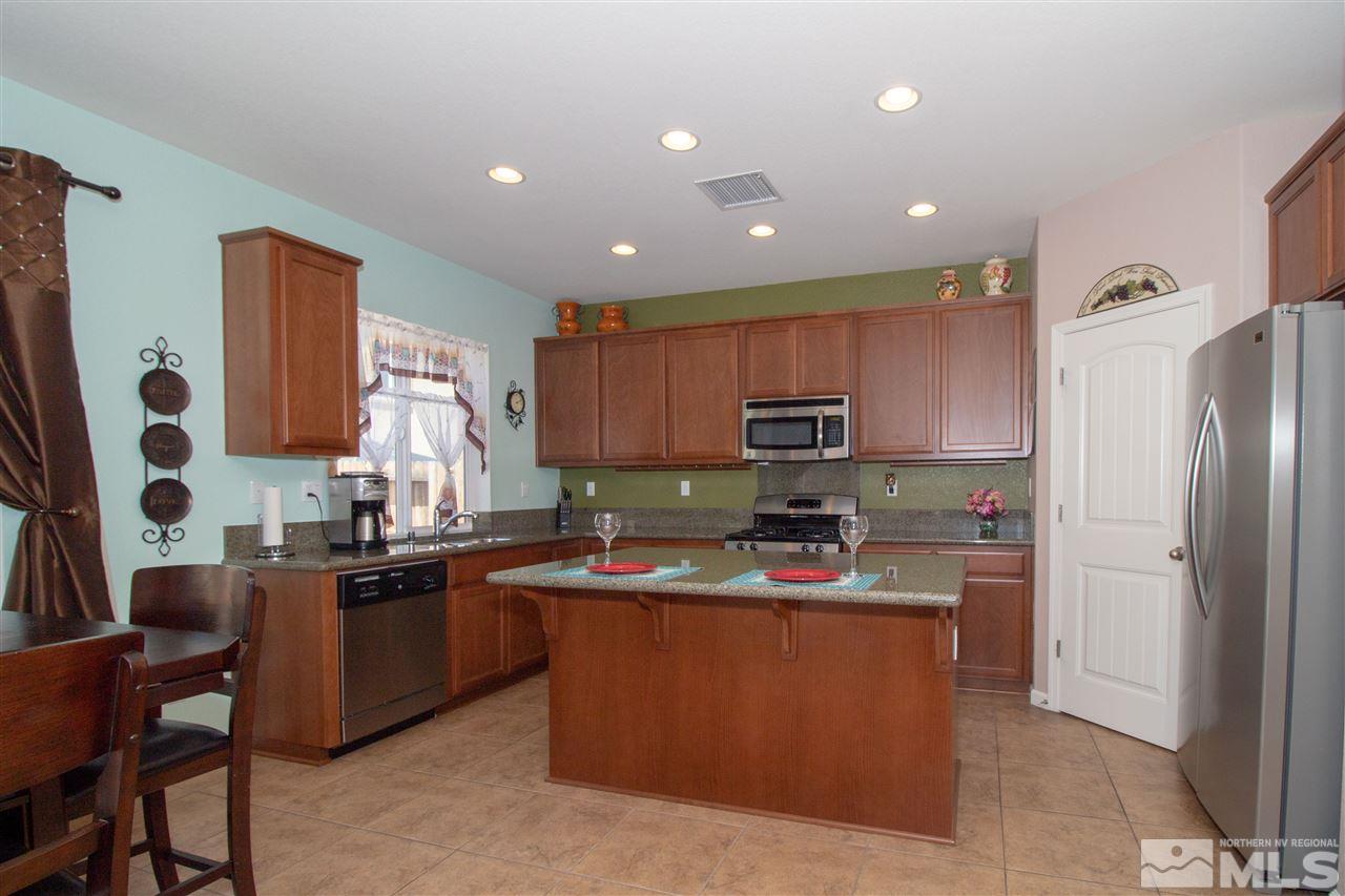 1945 Hope Valley Drive Reno, NV 89521 - Photo 5 of 22 a kitchen with kitchen island granite countertop a sink refrigerator stove and microwave