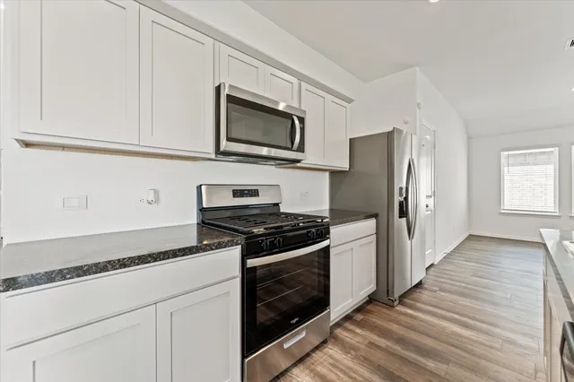 a kitchen with stainless steel appliances a stove microwave and refrigerator