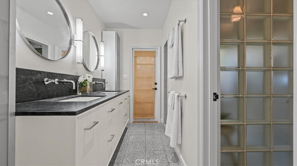 460 University Circle Claremont, CA 91711 - Photo 22 of 41 a bathroom with a granite countertop sink a mirror and a shower