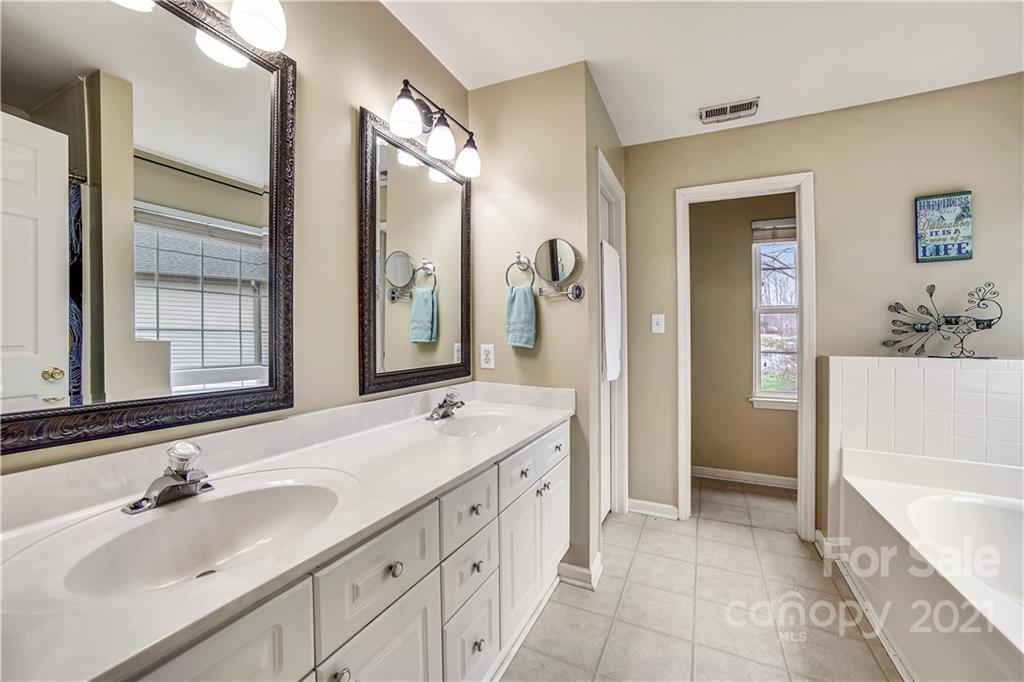 3795 Kennedy Road Gastonia, NC 28056 - Photo 16 of 32 a spacious bathroom with a double vanity sink a mirror a bathtub and