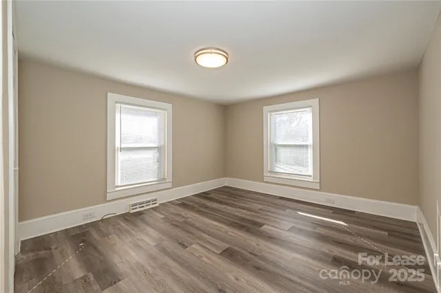 an empty room with wooden floor and window