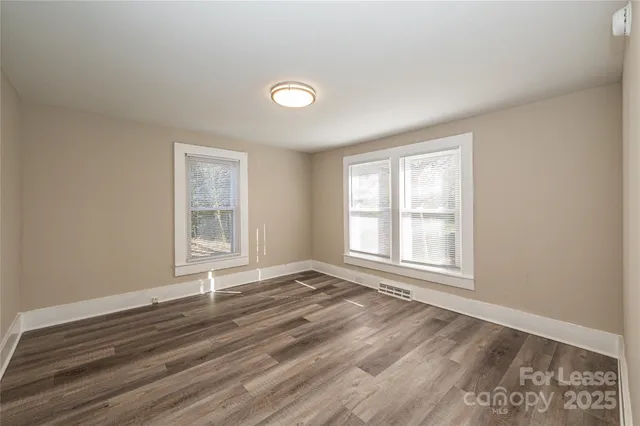 a view of a room with wooden floor and a window