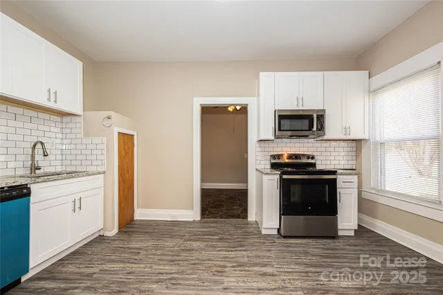 a kitchen with stainless steel appliances a stove microwave and sink