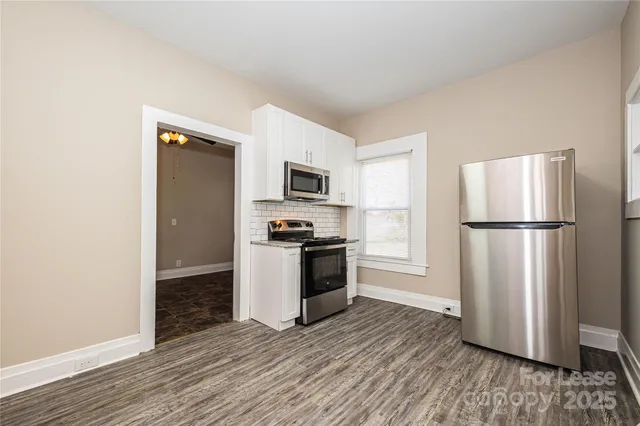 a kitchen with wooden floors and appliances
