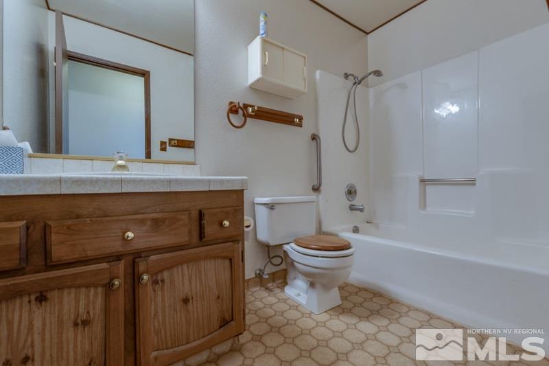 1670 Alamo Street Reno, NV 89503 - Photo 17 of 25 a bathroom with a granite countertop toilet a sink and a mirror