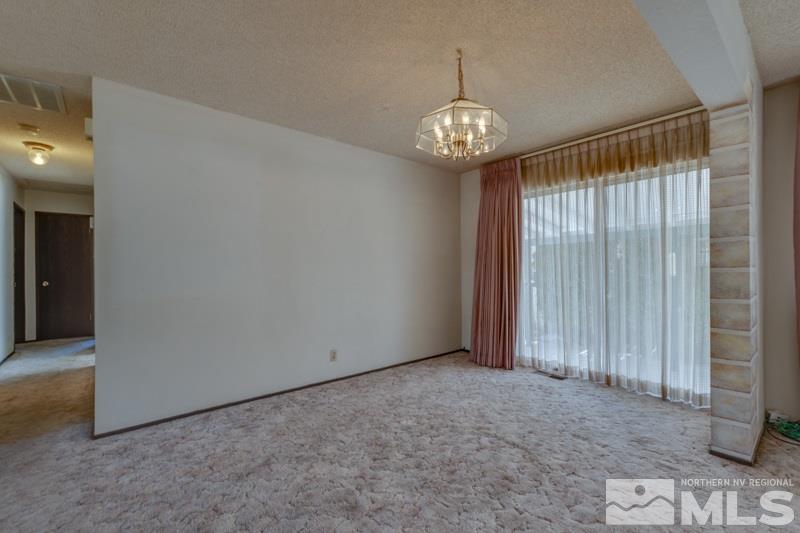 1670 Alamo Street Reno, NV 89503 - Photo 8 of 25 an empty room with a chandelier fan and windows