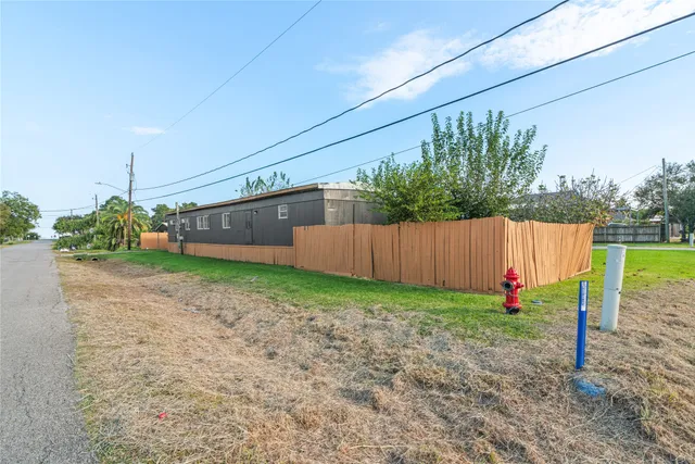 a view of a backyard with plants and wooden fence