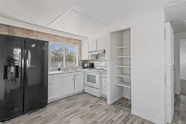 a kitchen with a refrigerator stove and sink