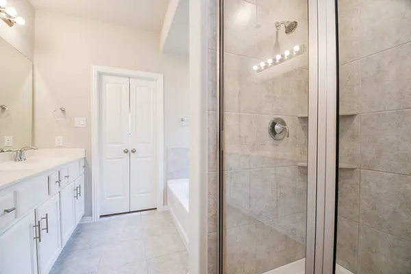 a bathroom with a double vanity sink a shower and a mirror