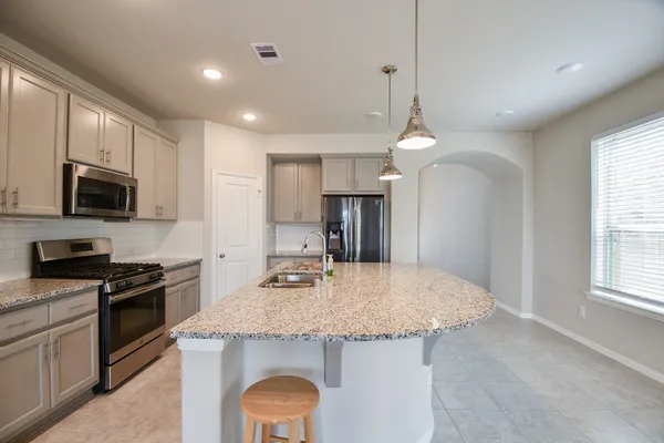 a kitchen with stainless steel appliances granite countertop a sink stove and refrigerator